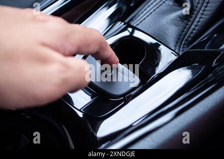 Appuyez à la main sur le bouton de frein à main électronique dans la voiture moderne de luxe Banque D'Images