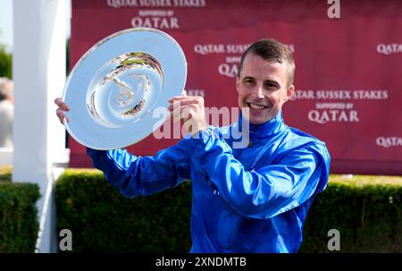 Le jockey William Buick célèbre avec le trophée après avoir remporté les Qatar Sussex Stakes avec un discours remarquable lors de la deuxième journée du Festival Qatar Goodwood à l'hippodrome de Goodwood, Chichester. Date de la photo : mercredi 31 juillet 2024. Banque D'Images