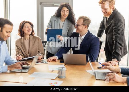 Professionnels travaillant autour d'une table dans un bureau moderne Banque D'Images