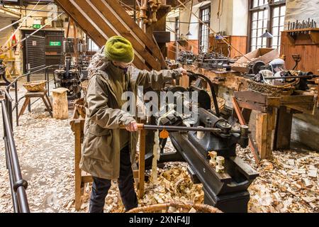 CUMBRIA, Royaume-Uni - 25 avril 2024. Femme faisant une démonstration de machines au musée de travail de Stott Park Bobbin Mill dans Lake District, Royaume-Uni Banque D'Images