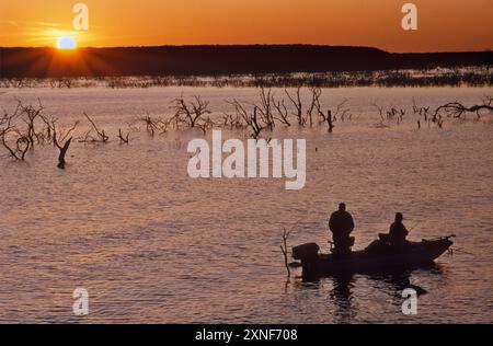 Pêcheurs en bateau près de Frio Bend Ramp, Choke Canyon Reservoir, Choke Canyon State Park, au coucher du soleil, printemps, South Texas Region, Texas, ÉTATS-UNIS Banque D'Images