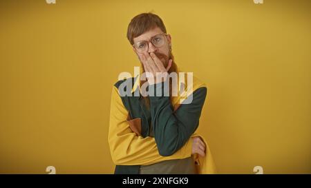 Bel homme barbu rousse dans une tenue rétro contemplant sur un fond jaune Banque D'Images