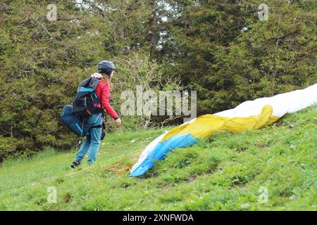 Une femme parapente complète ses derniers préparatifs avant de décoller d'une montagne du sud de la Bavière. La scène capture l'anticipation et le thril Banque D'Images