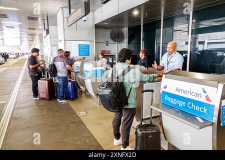 Miami Florida, Miami International Airport, intérieur intérieur à l'intérieur, voyageurs noirs africains, enregistrement sur le trottoir, bagages, agent homme femme, américain A Banque D'Images