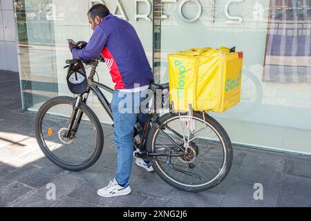 Barcelone Espagne, Catalogne Catalunya, Carrer de Tarragona Eixample, Glovo vélo Courier livraison service de nourriture travailleur autonome cavalier homme, Afrique du Nord, GIG Banque D'Images