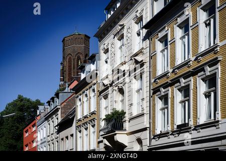 Vieux bâtiments aux couleurs pastel soigneusement restaurés dans le quartier de Lindenthal à cologne avec la tour de la famille Stephan en arrière-plan Banque D'Images