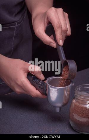 Femme Barista utilise une machine pour préparer un délicieux café, gros plan des mains à l'aide de la cafetière à piston Banque D'Images