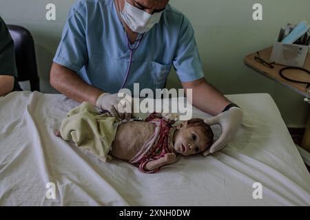 25 juillet 2024, Syrie, Atimah : un travailleur de la santé suit l’état d’un bébé dans l’unité de soins intensifs de l’hôpital HIHFAD dans la ville d’Atimah. Les résidents des camps du nord-ouest de la Syrie souffrent de conditions humanitaires difficiles en raison d'un manque de financement. Cela a conduit à l'arrêt des distributions de paniers alimentaires dans la plupart des camps, ce qui a entraîné une augmentation des cas de malnutrition en 2024 par rapport aux années précédentes. Selon un rapport de l’OCHA, 50 pour cent des établissements de santé cesseront de fonctionner complètement ou partiellement en décembre, et le nombre de personnes souffrant de nourriture Banque D'Images