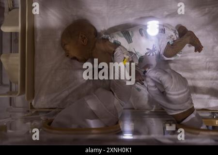 25 juillet 2024, Syrie, Atimah : un travailleur de la santé suit l’état d’un bébé dans l’unité de soins intensifs de l’hôpital HIHFAD dans la ville d’Atimah. Les résidents des camps du nord-ouest de la Syrie souffrent de conditions humanitaires difficiles en raison d'un manque de financement. Cela a conduit à l'arrêt des distributions de paniers alimentaires dans la plupart des camps, ce qui a entraîné une augmentation des cas de malnutrition en 2024 par rapport aux années précédentes. Selon un rapport de l’OCHA, 50 pour cent des établissements de santé cesseront de fonctionner complètement ou partiellement en décembre, et le nombre de personnes souffrant de nourriture Banque D'Images