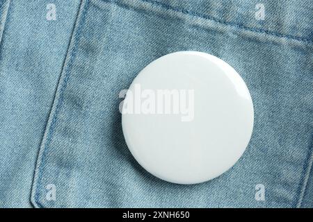 Badge bouton blanc épinglé sur la chemise en Jean, vue de dessus. Maquette pour le design Banque D'Images