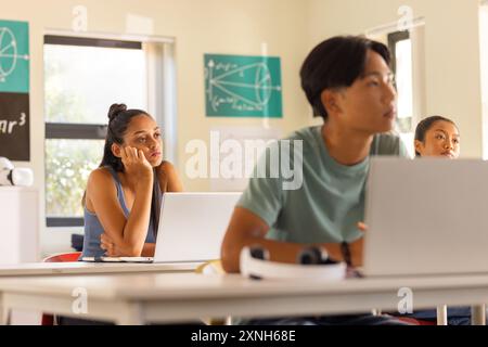 Au lycée, les adolescents utilisent des ordinateurs portables et écoutent attentivement en classe Banque D'Images