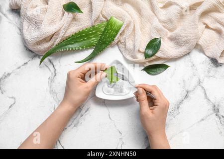 Femme faisant du gel d'aloe vera sur fond blanc Banque D'Images