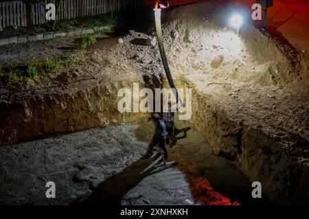 17 août 2023 Eskisehir Turquie. Hommes de constructeur versant du ciment sur les fondations du bâtiment la nuit Banque D'Images