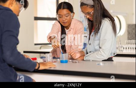 Au lycée, les adolescents menant des expériences scientifiques avec des lunettes de sécurité en classe Banque D'Images