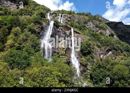 L'eau descend en cascade à flanc de montagne à partir de trois cascades, entouré d'une végétation luxuriante dans les alpes italiennes Banque D'Images
