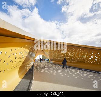 Auvent perforé de bicyclette et pont piétonnier. Swansea Arena et Copr Bay Bridge, Swansea, Royaume-Uni. Architecte : acme, 2024. Banque D'Images