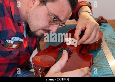 Luthier réparant et améliorant violon bon marché Banque D'Images