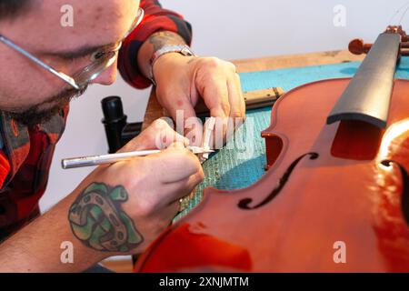 Luthier réparant et améliorant violon bon marché Banque D'Images