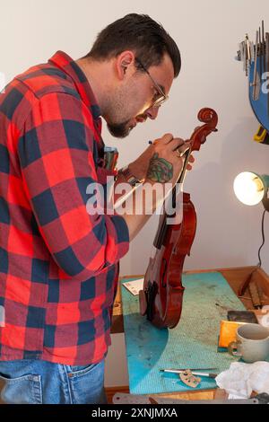 Luthier réparant et améliorant violon bon marché Banque D'Images