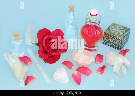 Fleur de rose Love potion sorcellerie concoction dans une bouteille en forme de coeur pour l'amour sans retour ou la Saint-Valentin. Préparation avec des cristaux de rose et de quartz. Banque D'Images