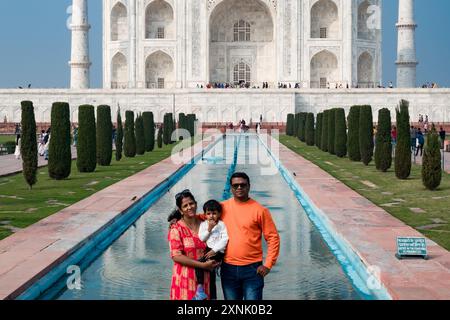 Agra, Inde 02/14/2024 famille indienne prenant un phot devant le célèbre mausolée Taj Mahal contre le ciel bleu Banque D'Images