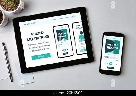 Application de méditation sur tablette et écran de smartphone sur la table grise. Concept d'application de santé mentale. Vue de dessus Banque D'Images