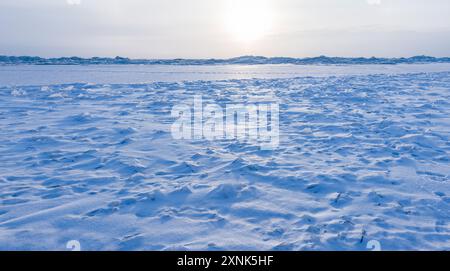 Paysage d'hiver avec la glace de la mer Baltique gelée sous le ciel bleu par une journée ensoleillée. Des fragments de glace tranchants sont recouverts de neige Banque D'Images