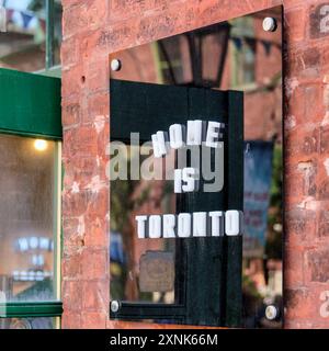 Toronto, Canada - 29 juillet 2024 : enseigne commerciale dans un mur de briques. On peut lire Home is Toronto et il est situé dans le quartier des distilleries Banque D'Images