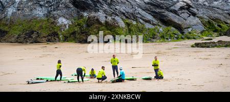 Une image panoramique d’un moniteur de surf de l’Escape Surf School avec ses apprenants novices de surf au début d’une leçon de surf sur Towan Beac Banque D'Images