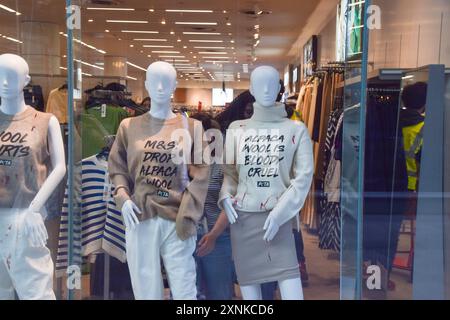 Londres, Royaume-Uni. 1er août 2024. Les militants de PETA placent des mannequins portant des vêtements en fausse laine arrosés de faux sang, et avec des slogans exhortant le détaillant à cesser de vendre des vêtements en laine d'alpaga, dans la vitrine du magasin Marks and Spencer à Victoria. L'action fait partie de la campagne en cours du groupe de défense des droits des animaux contre l'utilisation de la laine d'alpaga. Crédit : Vuk Valcic/Alamy Live News Banque D'Images