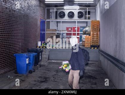 Un étudiant a vu une benne plonger pour trouver de la nourriture et des produits encore utilisables devant un supermarché à Berlin, en Allemagne. Banque D'Images