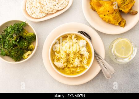 Ragoût de lapin avec du riz, du brocoli et des gâteaux de riz, servi table avec de la nourriture, délicieux déjeuner copieux ou dîner Banque D'Images