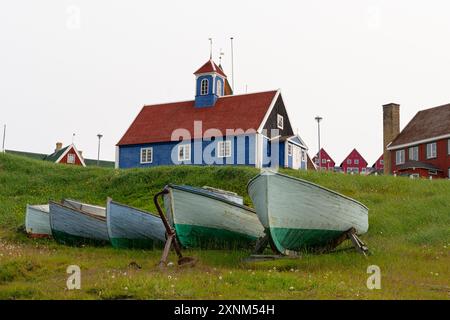 Cinq bateaux de pêche devant l'église bleue de Bethel à Sisimiut. Qeqqata Kommunia. Groenland, Royaume de Danemark Banque D'Images