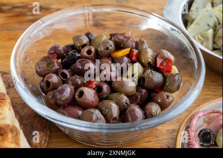 Olives marinées et marinées, artichauts, légumes sur table en bois, variété de savoureuses entrées italiennes, antipasti, tapas en gros plan Banque D'Images
