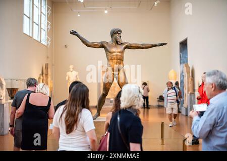 ATHÈNES, Grèce — la statue de Zeus ou Poséidon, une sculpture en bronze frappante du Ve siècle av. J.-C., est l'une des expositions les plus célèbres du Musée archéologique national d'Athènes. Cette sculpture emblématique, découverte dans la mer au large du cap Artemision, est censée représenter soit Zeus, tenant un coup de foudre, soit Poséidon, brandissant un trident. La statue est célèbre pour sa pose dynamique et son artisanat complexe, illustrant l'excellence artistique des sculpteurs grecs antiques. Banque D'Images