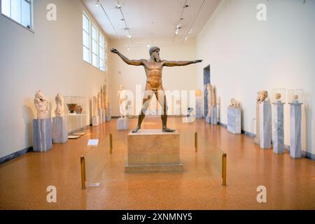 ATHÈNES, Grèce — la statue de Zeus ou Poséidon, une sculpture en bronze frappante du Ve siècle av. J.-C., est l'une des expositions les plus célèbres du Musée archéologique national d'Athènes. Cette sculpture emblématique, découverte dans la mer au large du cap Artemision, est censée représenter soit Zeus, tenant un coup de foudre, soit Poséidon, brandissant un trident. La statue est célèbre pour sa pose dynamique et son artisanat complexe, illustrant l'excellence artistique des sculpteurs grecs antiques. Banque D'Images