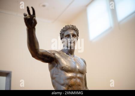 ATHÈNES, Grèce — L'Ephèbe d'Antikythère, également connu sous le nom de Jeunesse d'Antikythère, est une sculpture en bronze exposée au Musée archéologique national d'Athènes. Récupérée du naufrage d'Antikythère, cette statue remonte à la fin du IVe siècle av. J.-C. et représente une figure masculine jeune idéalisée, mettant en valeur l'importance artistique et culturelle de la période hellénistique. L'Ephèbe d'Antikythère est connu pour sa représentation réaliste et son artisanat complexe, soulignant l'excellence des sculpteurs grecs antiques. Banque D'Images