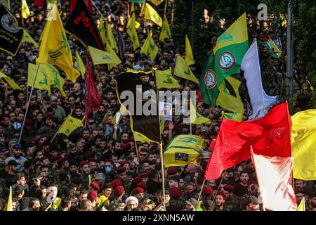 Beyrouth, Liban. 01 août 2024. Les gens brandissent des drapeaux pendant les funérailles du commandant du Hezbollah Fuad Shukr dans la banlieue sud de Beyrouth. Shukr a été tué dans une frappe israélienne qui a également coûté la vie à cinq civils et blessé des dizaines. Crédit : Marwan Naamani/dpa/Alamy Live News Banque D'Images