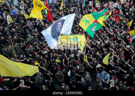 Beyrouth, Liban. 01 août 2024. Les gens brandissent des drapeaux pendant les funérailles du commandant du Hezbollah Fuad Shukr dans la banlieue sud de Beyrouth. Shukr a été tué dans une frappe israélienne qui a également coûté la vie à cinq civils et blessé des dizaines. Crédit : Marwan Naamani/dpa/Alamy Live News Banque D'Images