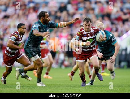 Harry Smith des Warriors est attaqué par Leroy Cudjoe des Huddersfield Giants (à gauche) lors du match de Betfred Super League au Brick Community Stadium de Wigan. Date de la photo : jeudi 1er août 2024. Banque D'Images