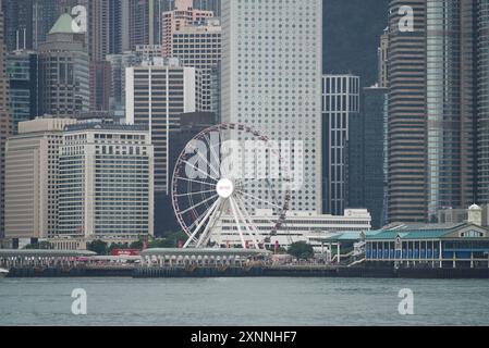 La roue d'observation sur la rive du port. Hong Kong - 26 mai 2024 Banque D'Images