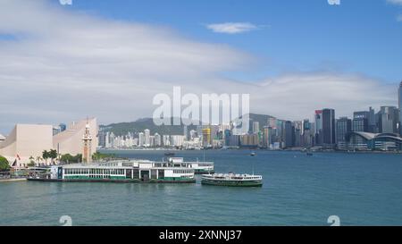 Le Star Ferry sur le port de Victoria par une journée ensoleillée avec l'horizon de Hong Kong en arrière-plan. Hong Kong - 12 juin 2024 Banque D'Images