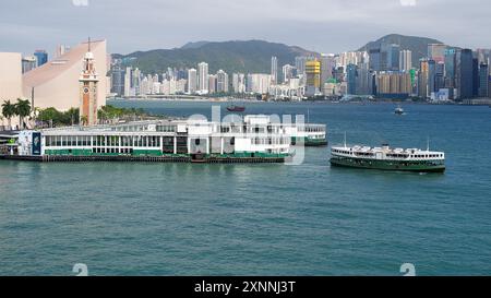 Le Star Ferry sur le port de Victoria par une journée ensoleillée avec l'horizon de Hong Kong en arrière-plan. Hong Kong - 12 juin 2024 Banque D'Images