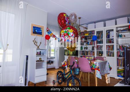 Belle vue sur la chambre décorée pour l'anniversaire de l'enfant, avec vélo emballé avec ballons sur le thème Mario. Banque D'Images