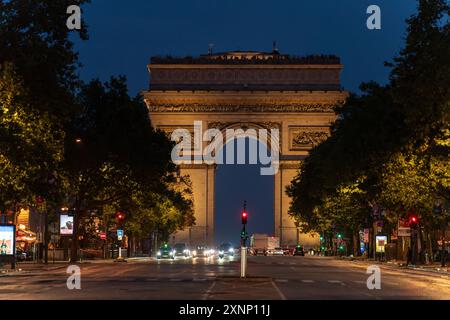 Paris, France - 31 juillet 2024 : illumine l'Arc de Triomphe la nuit avec une circulation animée Banque D'Images