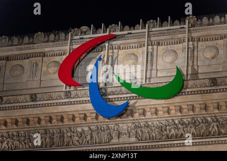 Paris, France - 31 juillet 2024 : gros plan du logo des Jeux Paralympiques sur l'Arc de Triomphe la nuit Banque D'Images