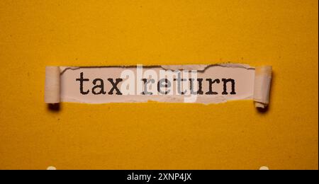 pot de sauvegarde plein de pièces et mini tableau noir avec texte déclaration d'impôt Banque D'Images