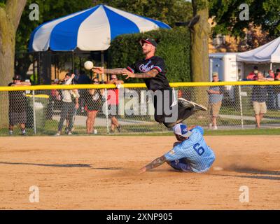 Un joueur de terrain échappe à un Baserunner tentant de rompre un double jeu lors d'un match de softball de 16 pouces, qui est populaire dans la région de Chicago. Banque D'Images