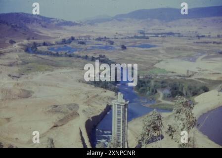 La construction du barrage de Blowing un remblai rocheux non gainé avec un barrage de remblai à noyau d'argile avec un déversoir de goulotte en béton sur la rivière Tumut au début des années 1960, partie du Snowy Mountains Hydro Electric and irrigation Scheme. Banque D'Images