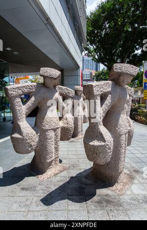 1er août 2024. Vue verticale d'une sculpture en pierre représentant trois femmes Samsui portant une lourde charge sur leur épaule. Singapour. Banque D'Images